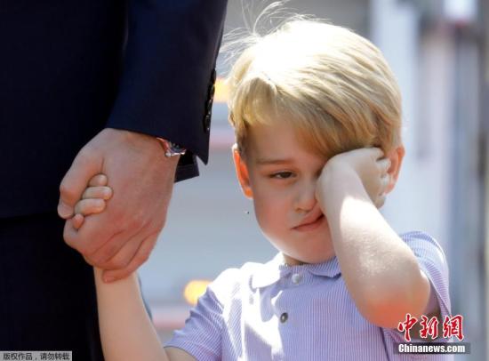 乔治小王子牵着爸爸的手，看起来睡意朦胧，不停揉眼。