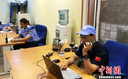 图为：两位中国维和警察在指挥中心协调防爆队设卡（左为韦益毅）。浙江省公安厅供图