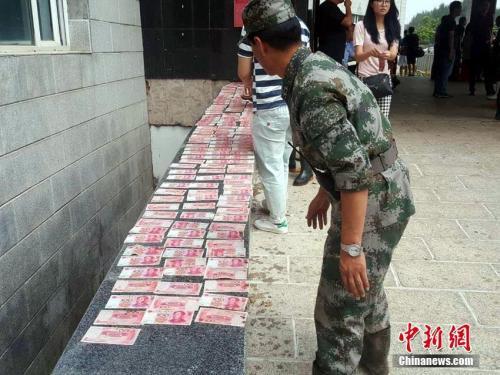 资料图:吉林永吉洪灾后清淤现3万现金,救灾官兵全上交。苍雁 摄
