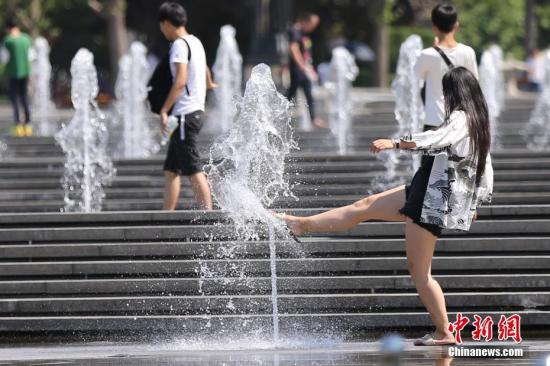 7月24日，游客在大雁塔喷泉广场嬉水。当日，西安市气象台继续发布高温红色预警信号。20日开始，西安已经连续4天气温在40℃以上，历史同期也是首次出现。中新社记者 张远 摄