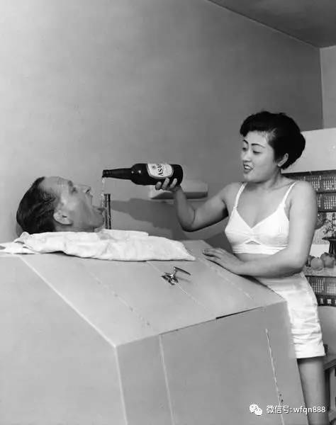 1950年前后，一名艺妓正往洗蒸气浴的客人嘴里倒啤酒。