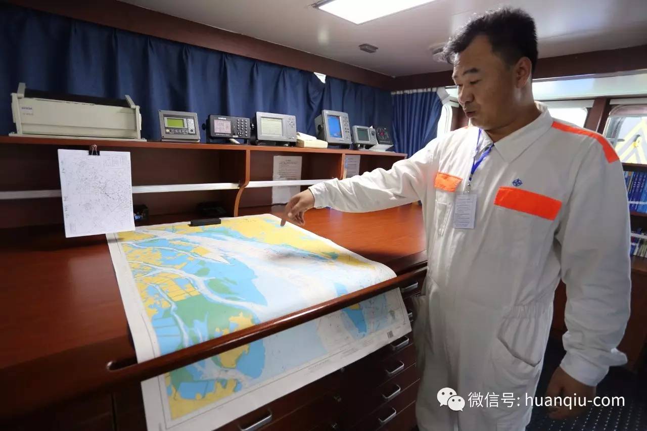 “天鲸”号前船长王明安在给记者看水路图。