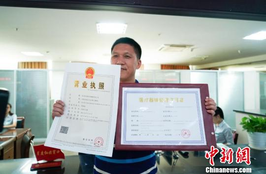 一市民同时拿到了营业执照与医疗器械经营许可证。 胡军 摄