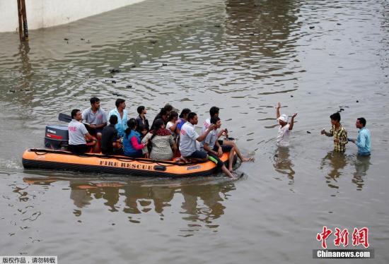 当地时间7月27日，印度艾哈迈达巴德，当地消防人员正在疏散被洪水围困的群众。