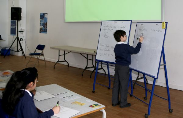 资料图片：“九九乘法表”走进英国小学课堂。在英国伦敦东北部埃塞克斯郡的哈里斯小学，一名三年级（相当于国内二年级）的小学生在白板上用竖式计算。 新华社记者韩岩摄