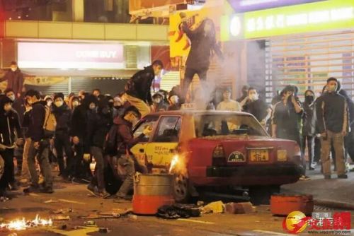 “旺角暴乱”，有暴徒用砖头砸毁停泊在路边的士及大肆破坏。（图片来源：文汇网）
