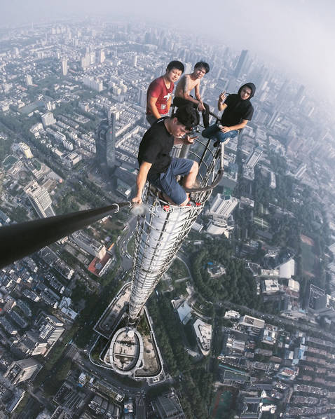 惊险！四小伙徒手爬大厦顶塔尖拍照 自称“就是瞎上”
