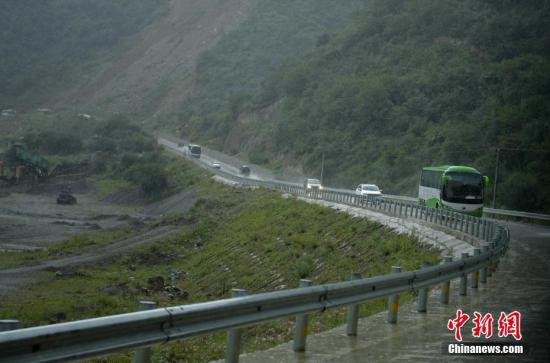 大客车载着游客冒雨撤离。 <a target=\'_blank\' href=\'http://www.chinanews.com/\'>中新社</a>记者 刘忠俊 摄