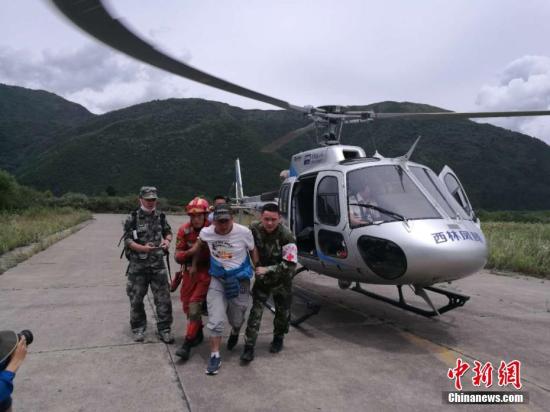 8月10日,“8.8”九寨沟地震抗震救灾指挥部派出两架直升机编队飞行前往四川九寨沟景区搜救。图为被成功搜救出的被困民众。 中新网记者 安源 摄