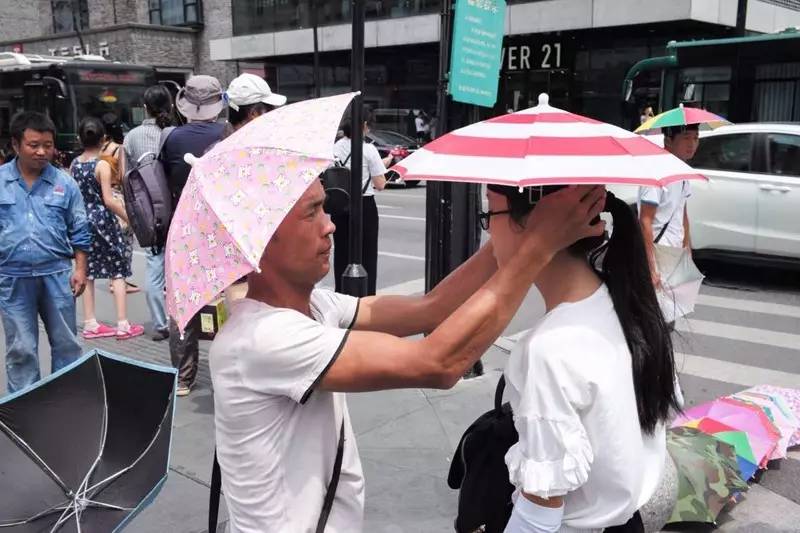这种戴在头上像雨伞一样的帽子,是今年夏天西湖边的爆款商品。