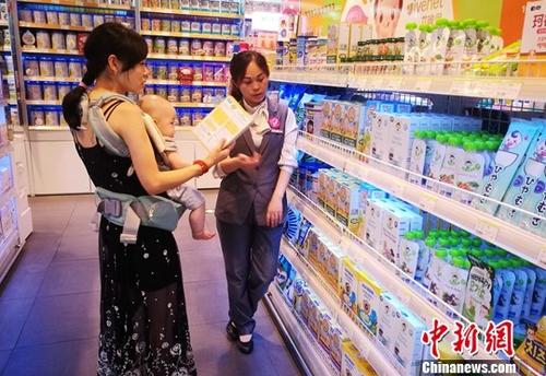 图为成都某超市内一位母亲带着孩子选购商品。 中新社记者 刘忠俊 摄