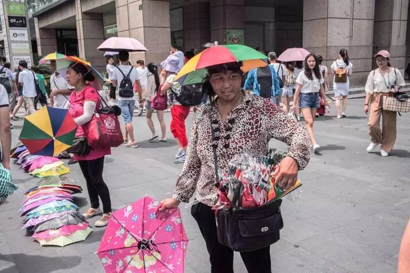 小贩们在人行横道的尽头占据有利位置,用帽子在地上摆出“八门金锁阵?#20445;?#24182;且主动出击招?#21487;?#24847;。