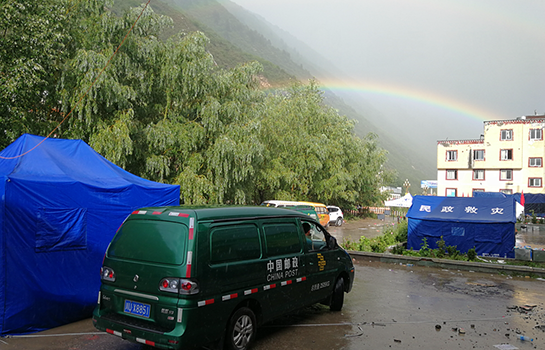 雨后彩虹下的邮车。