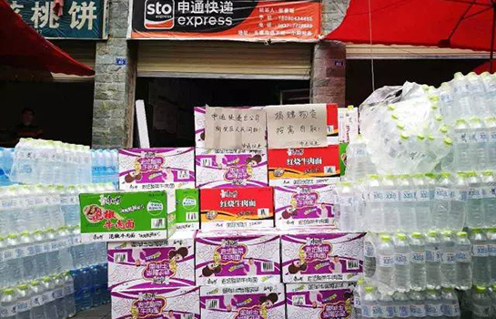 申通快递员为九寨沟灾民免费发放应抢救灾物资。