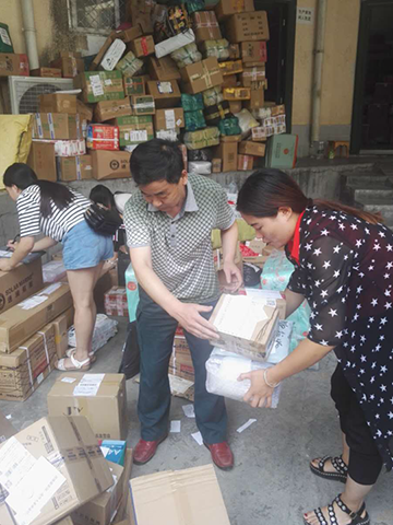 8月11日,漳扎邮政支局员工联系用户投递包裹。
