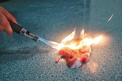 8月15日，记者用喷火器灼烧一块猪肉，10秒钟左右，猪肉表面出现烧煳变色的迹象。新京报记者 王嘉宁 摄