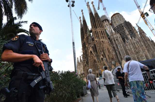 　8月20日，在西班牙巴塞罗那地标性建筑圣家族大教堂附近，一名警察持枪执勤。（新华/法新）