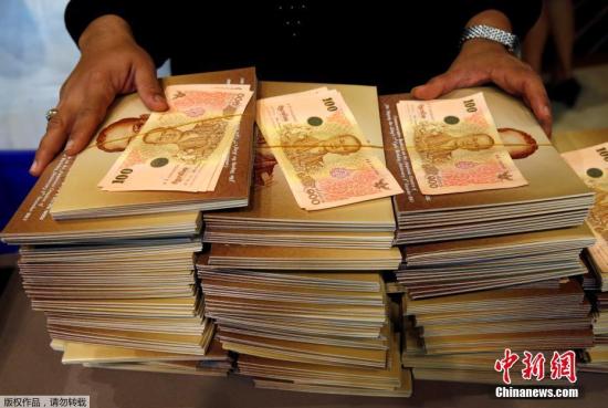 当地时间10月18日,泰国曼谷民众排队购买以国王普密蓬为主题的100泰铢纪念钞。
