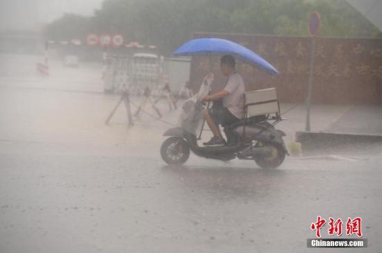 7月31日,暴雨侵袭福州,市民艰难出行。中新社记者 王东明 摄