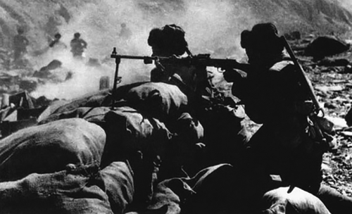 1962年中印疆域自卫还击战时代,解放军用机枪向敌人开火。