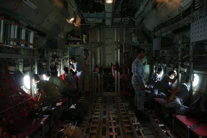 新加坡空军人员乘坐一架C-130飞机飞越搜索海域。