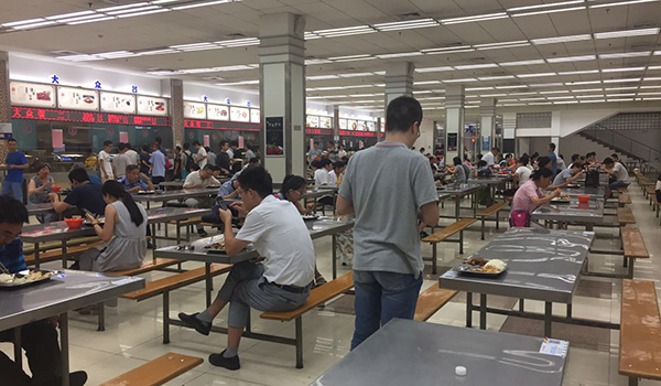 8月8日，不少游客在复旦邯郸校区旦苑食堂用餐。