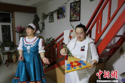 斯族姑娘介绍自己手工做的三角琴。 韩金龙 摄