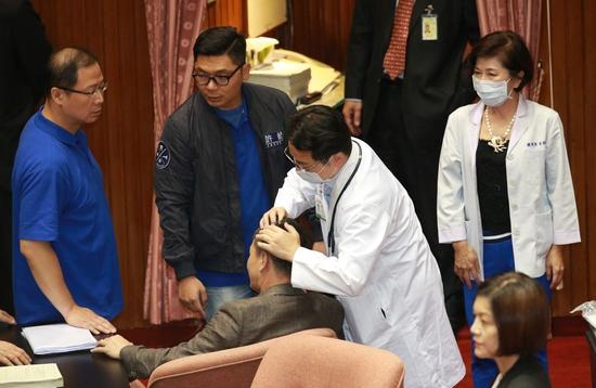 林为洲被民进党“立委”架下主席台，传出“挂彩”撞到头部。（图片来源：台湾联合新闻网）