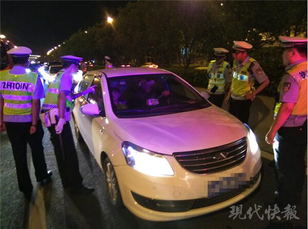 白色轿车被三辆警车团团包围,车内坐着一对男