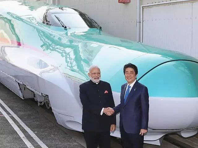 2016年11月12日,日本首相安倍晋三(右)与参观“新干线”列车生产厂的印度总理莫迪握手合影。(新华/法新)