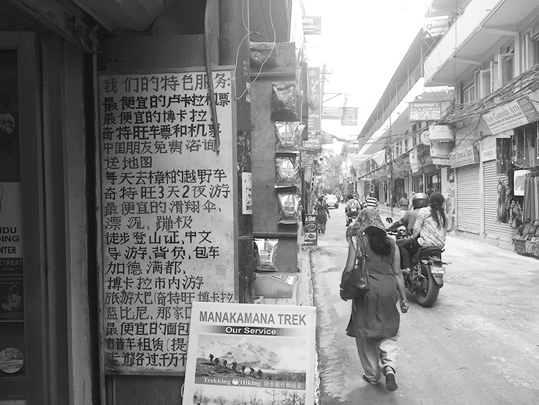尼泊尔街边，旅行社的中文招牌。范凌志摄
