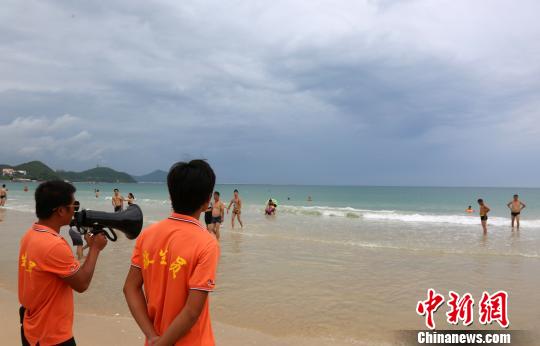 9月14日,三亚大东海景区海滩关闭,景区救生员提醒游客尽快离开海滩。 尹海明 摄