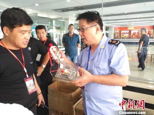 图为工商人员正在甄别白酒。驻马店市工商局开发分局供图