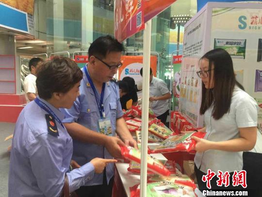 图为工商人员在展会上巡查。驻马店市工商局开发分局供图