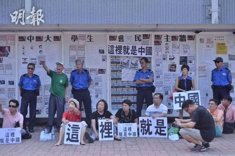 “爱港力”成员举“这里就是中国”标语，坐港中大“民主墙”前与中大生对峙
