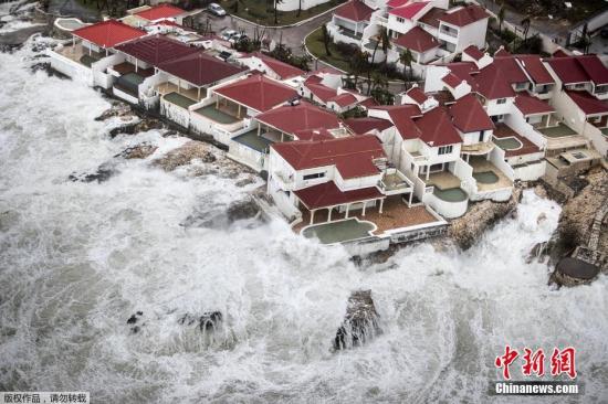 资料图：飓风“艾尔玛”经过时，航拍加勒比海边的几栋房屋如“孤岛”般被大浪包围。