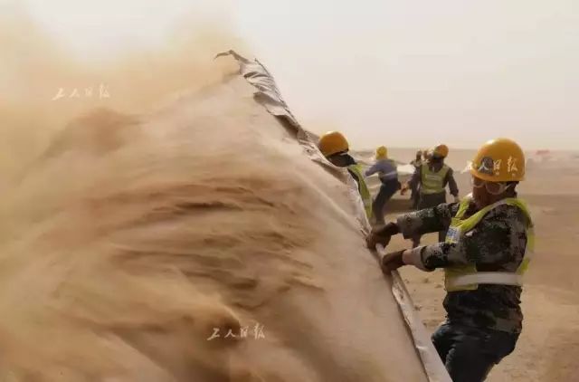 风沙大劲头更大,建设之初挑战恶劣情况。 (图片泉源:工人日报 黄朝华 摄)