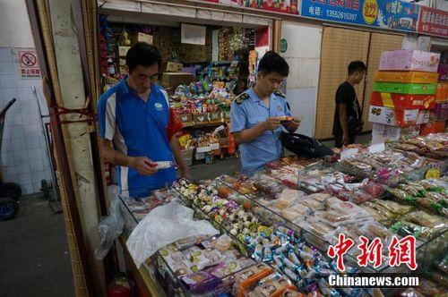 资料图:北京市食药监局执法工作人员在市场进行检查。北京通州区食药监局供图