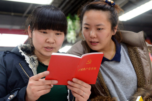 资料图片:2012年11月23日,两名读者在翻阅刚购置的《中国共产党章程》。新华社记者 林宏 摄
