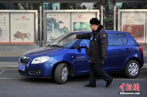 图为停车治理员为车主指挥倒车入位(资料图)。中新网记者 金硕 摄