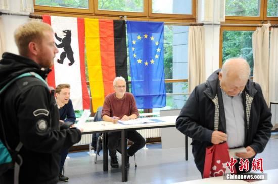 当地时间9月24日上午，德国第十九届联邦议院选举正式拉开帷幕。图为当天上午8时在首都柏林的一处投票站内，工作人员查验前来投票选民的证件。 中新社记者 彭大伟 摄
