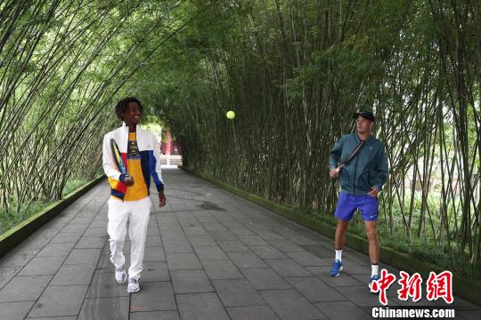 葱郁的竹林下,两位外籍球员进行网球表演。 钟欣 摄