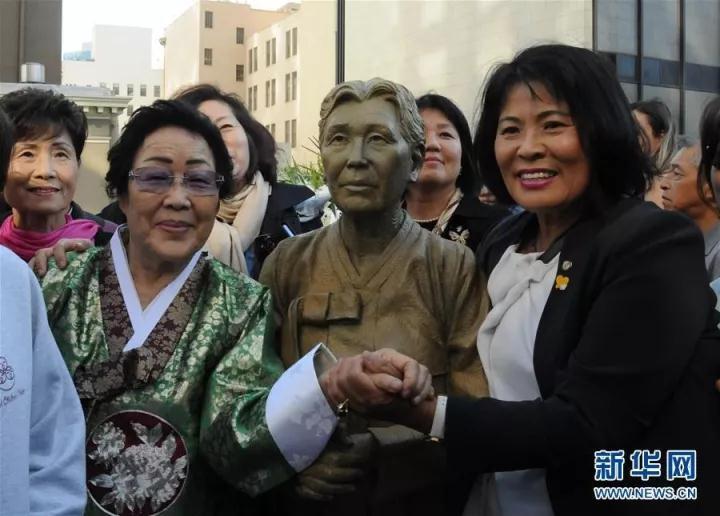 △来自韩国的“慰安妇”幸存者李容洙（前排左一）与一尊以首位公开讲述个人经历的韩国“慰安妇”金学顺为原型的塑像合影。