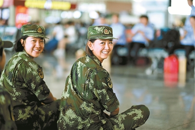 点击查看大图 女兵席地而坐候车,右一是郝然上尉
