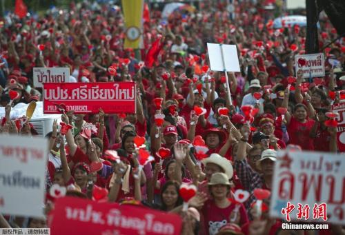 当地时间2014年5月11日，泰国曼谷，泰国“红衫军”高举英拉和他信的头像举行大规模集会，声援政府并抗议宪法法院等独立机构的“不公”。