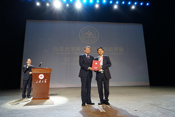 山東大學(xué)黨委書記郭新立向山大校友秦昶(右)頒發(fā)榮譽(yù)證書