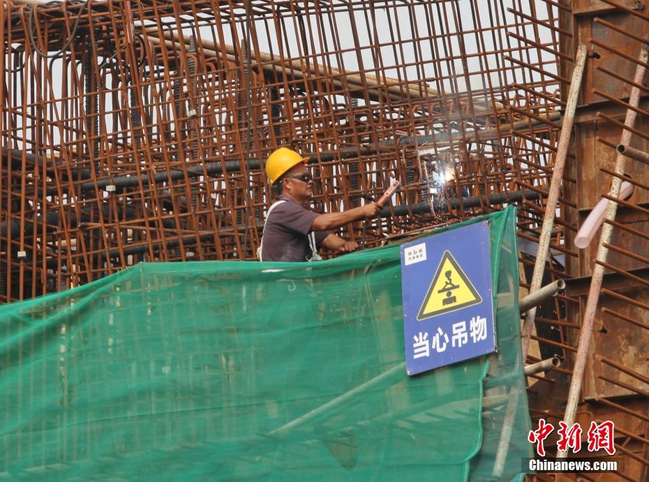 10月1日，建设者在四川眉山市东坡区岷江一桥改造工程施工现场忙碌。中新社发 姚永亮 摄 图片来源：CNSPHOTO