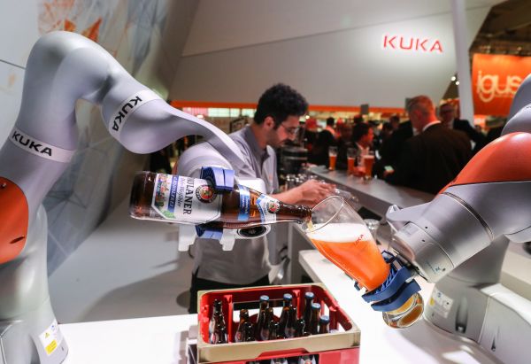  资料图片： 2017年4月24日，在德国汉诺威工业博览会上，两条机械臂在库卡公司展台为参观者倒啤酒。     新华社记者单宇琦