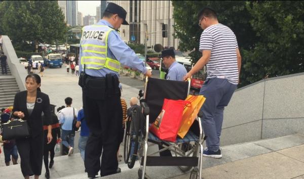 國慶安保巡邏時，陳建國幫助游客搬輪椅。