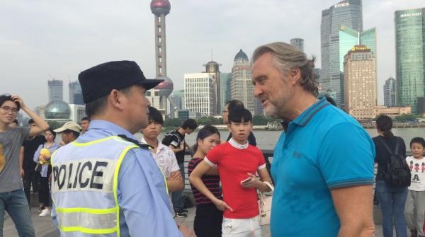 在外灘江堤，外國游客向陳建國詢問路線。